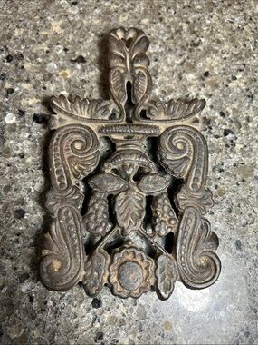 Iron trivet with decorative floral pattern